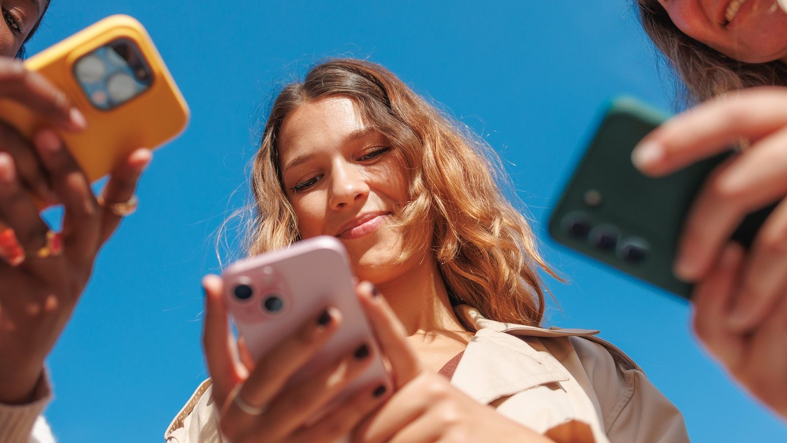 Jovens olhando o celular ao ar livre